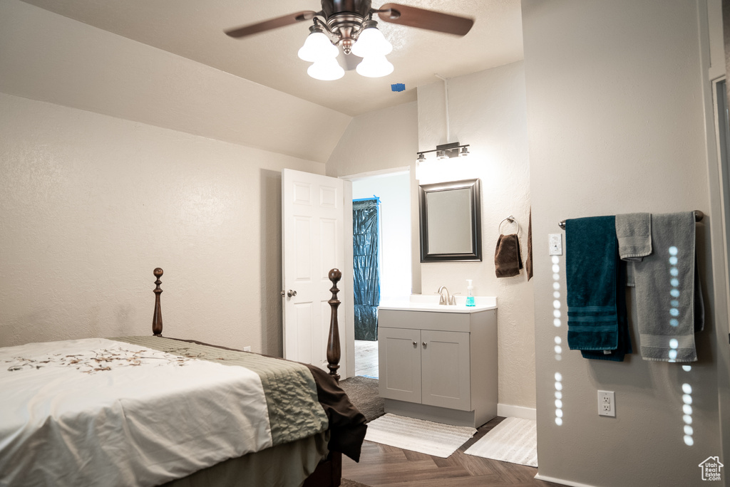 Bedroom featuring lofted ceiling, light parquet floors, ceiling fan, ensuite bathroom, and sink