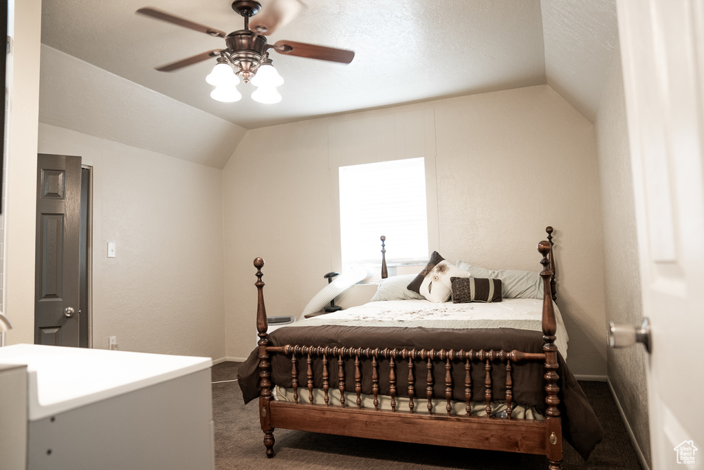 Carpeted bedroom featuring lofted ceiling and ceiling fan