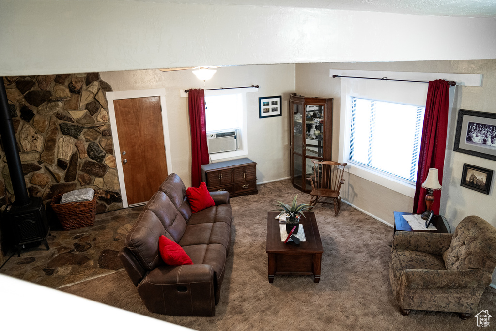 Living room with a wood stove, carpet flooring, and a textured ceiling