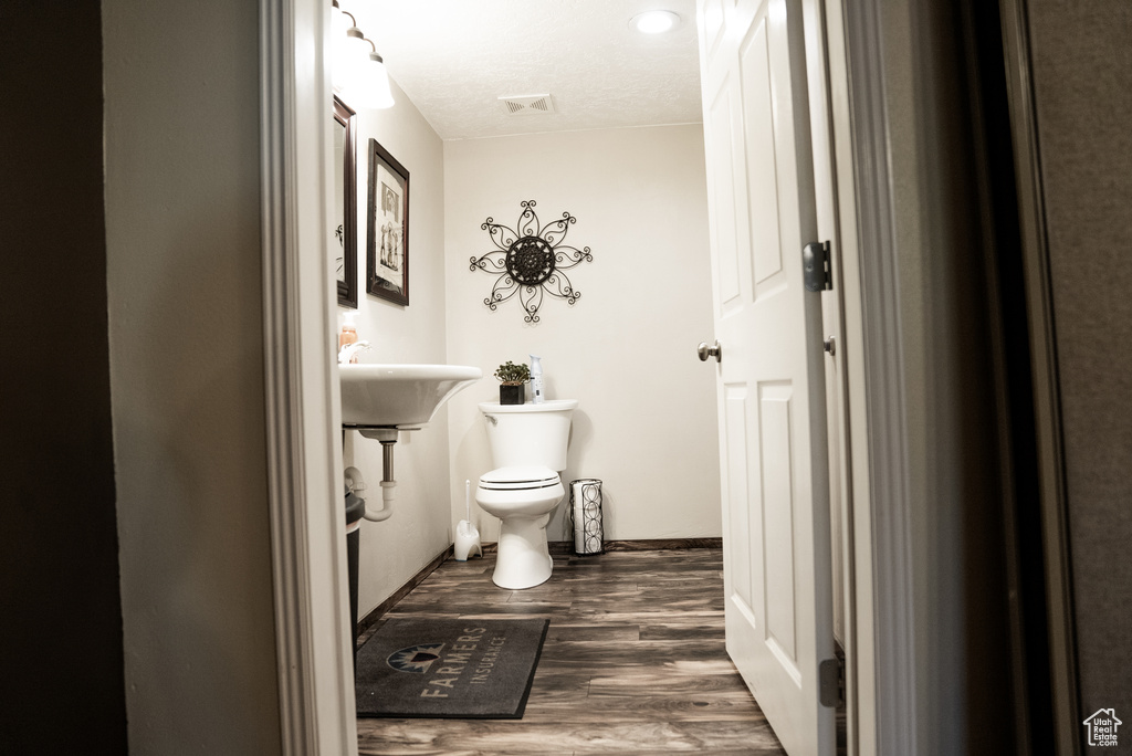 Bathroom featuring sink, toilet, and hardwood / wood-style flooring