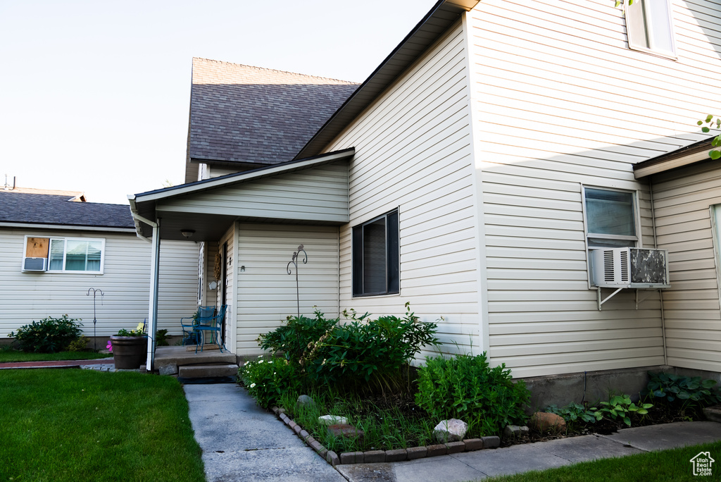 View of property exterior featuring cooling unit and a lawn