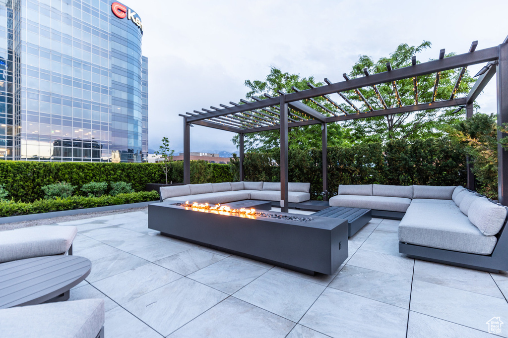 View of patio featuring an outdoor living space with a fire pit and a pergola