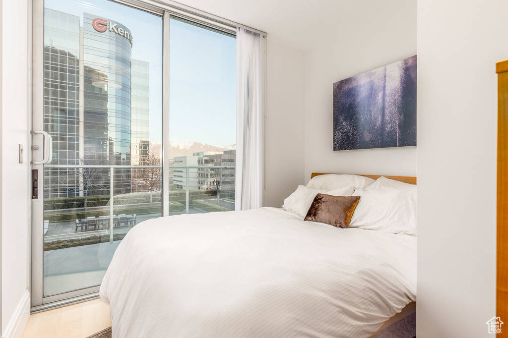 Bedroom featuring access to exterior, multiple windows, and hardwood / wood-style floors