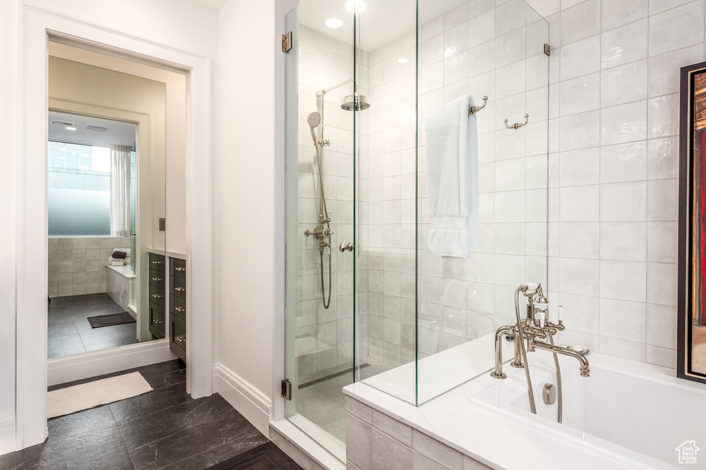 Bathroom with vanity, independent shower and bath, tile walls, and tile patterned floors