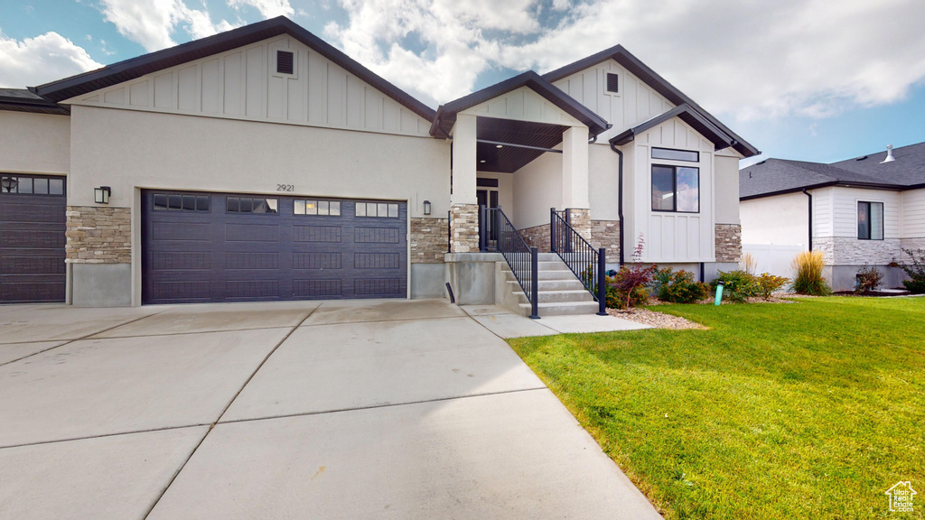 View of front of property with a front yard and a garage