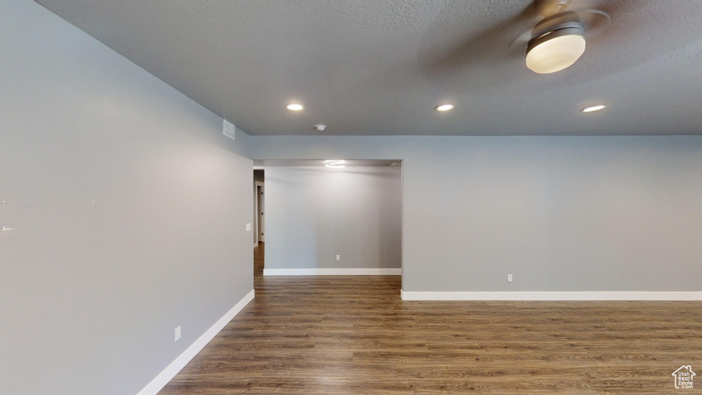 Spare room with a textured ceiling and dark wood-type flooring