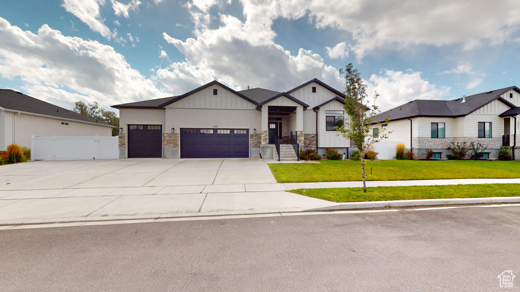 View of front of home with a garage and a front lawn