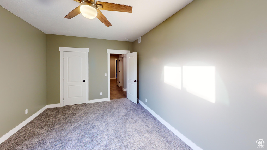 Unfurnished bedroom featuring carpet floors and ceiling fan