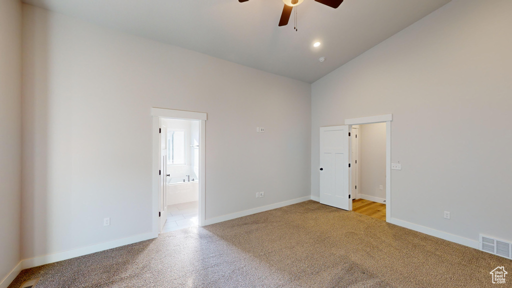 Interior space featuring high vaulted ceiling, carpet, and ceiling fan