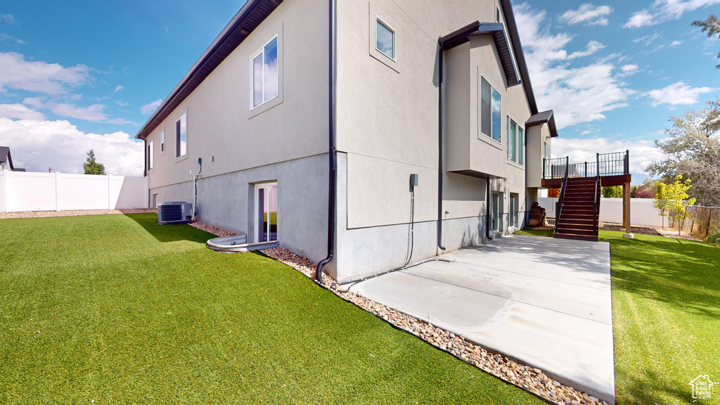 View of property exterior featuring a yard, central AC, and a patio area