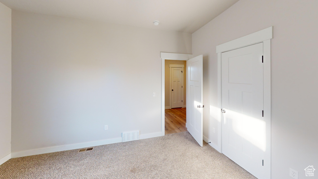 Unfurnished bedroom with light carpet