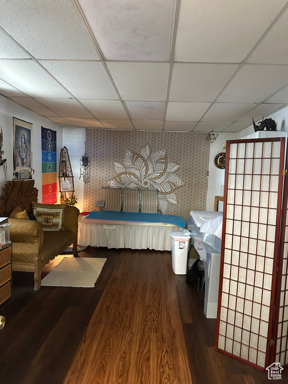 Bedroom featuring a paneled ceiling and dark hardwood / wood-style flooring