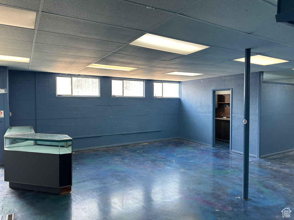 Basement featuring a healthy amount of sunlight and a paneled ceiling