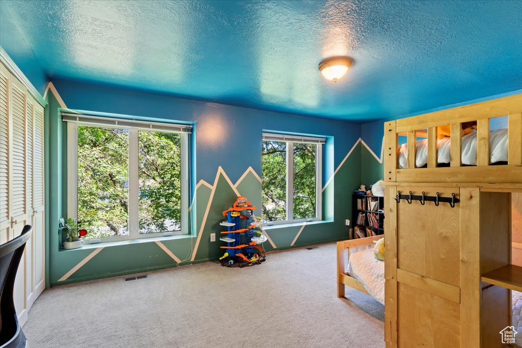 Carpeted bedroom featuring a closet and a textured ceiling