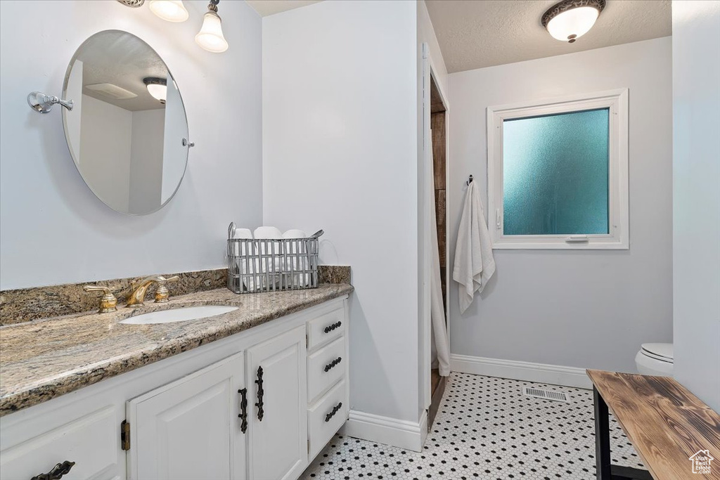 Bathroom with vanity, tile patterned flooring, and toilet