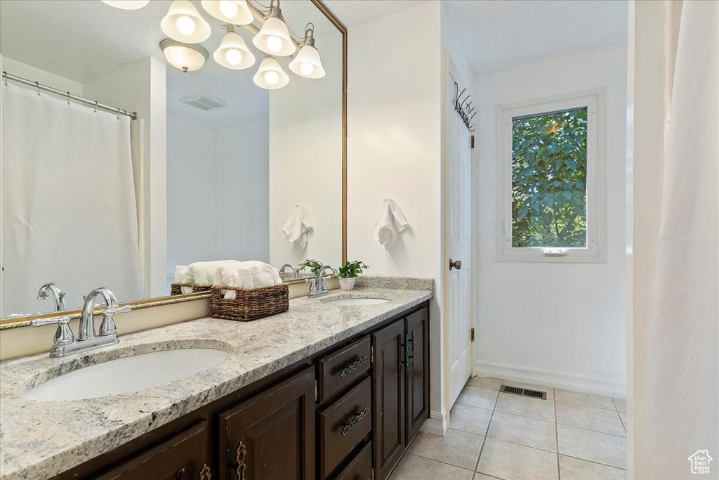 Bathroom with dual vanity and tile patterned flooring