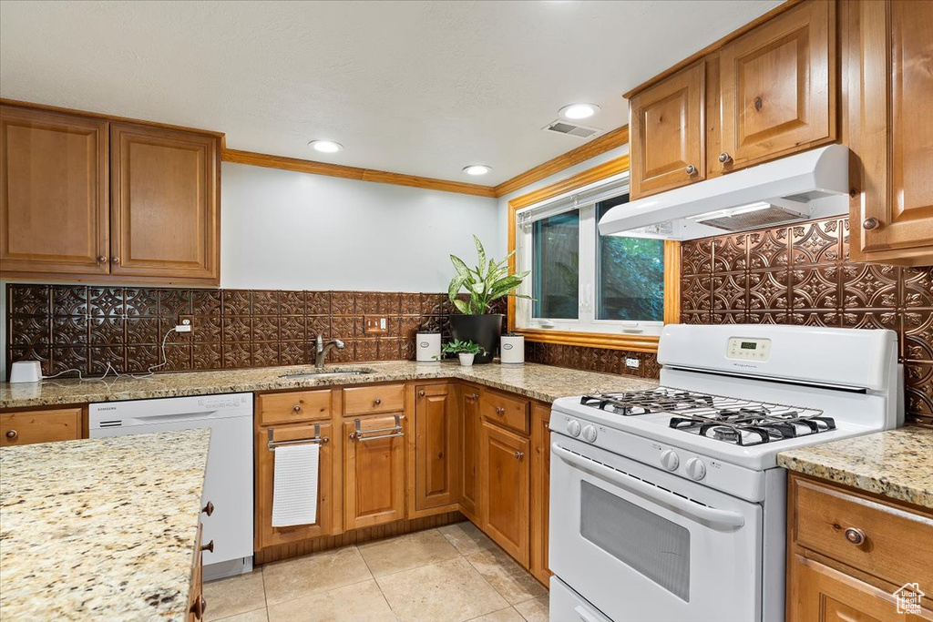 Kitchen with tasteful backsplash, white appliances, sink, and ornamental molding