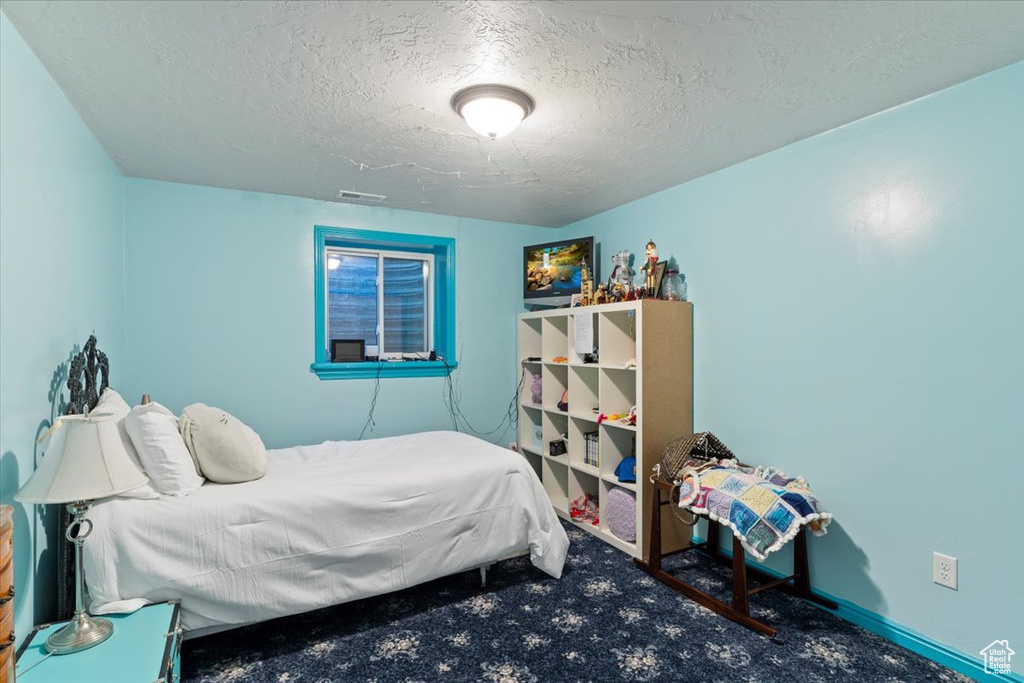 Carpeted bedroom with a textured ceiling