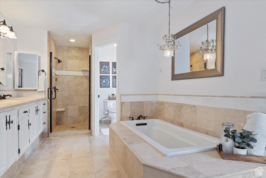 Full bathroom featuring tile patterned flooring, shower with separate bathtub, toilet, and vanity