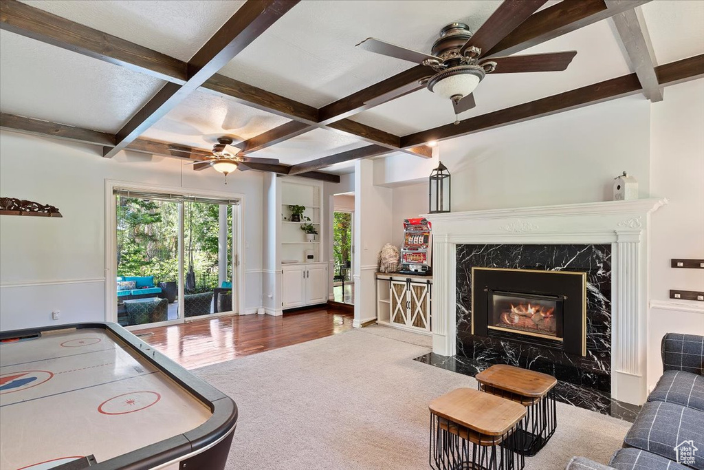 Interior space featuring a fireplace, hardwood / wood-style flooring, ceiling fan, beamed ceiling, and coffered ceiling