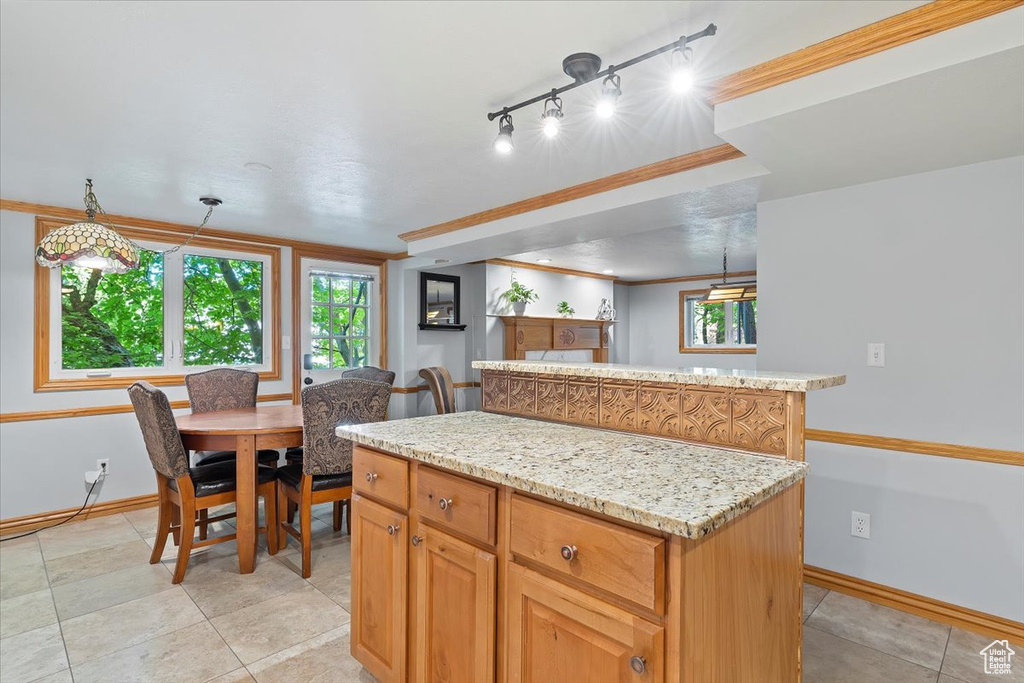 Kitchen featuring a center island, decorative light fixtures, rail lighting, and light tile patterned floors