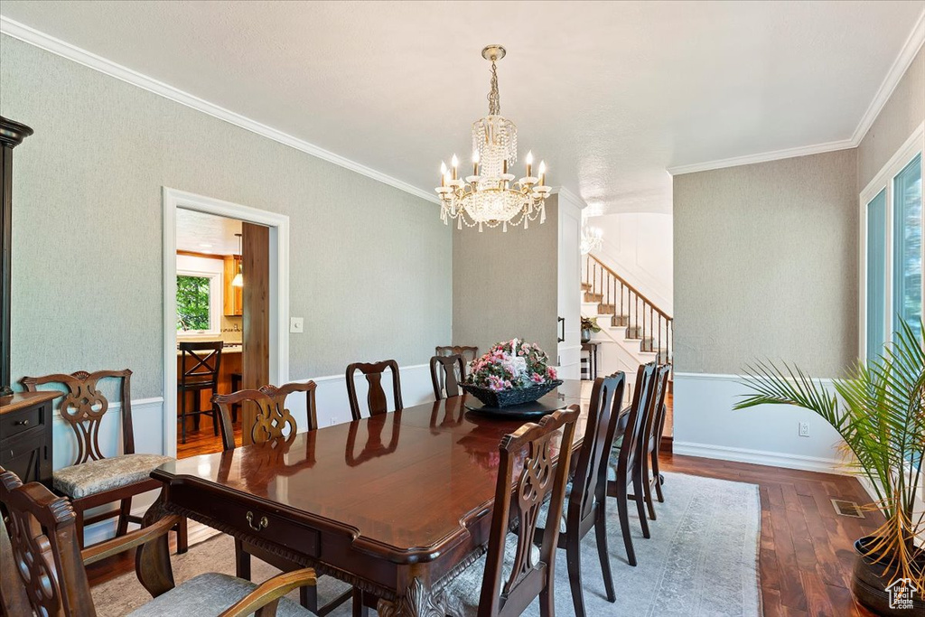 Dining area featuring ornamental molding, hardwood / wood-style floors, and an inviting chandelier