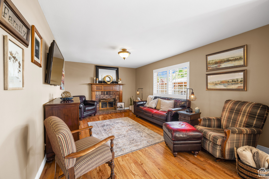 Living room with a fireplace and light wood-type flooring