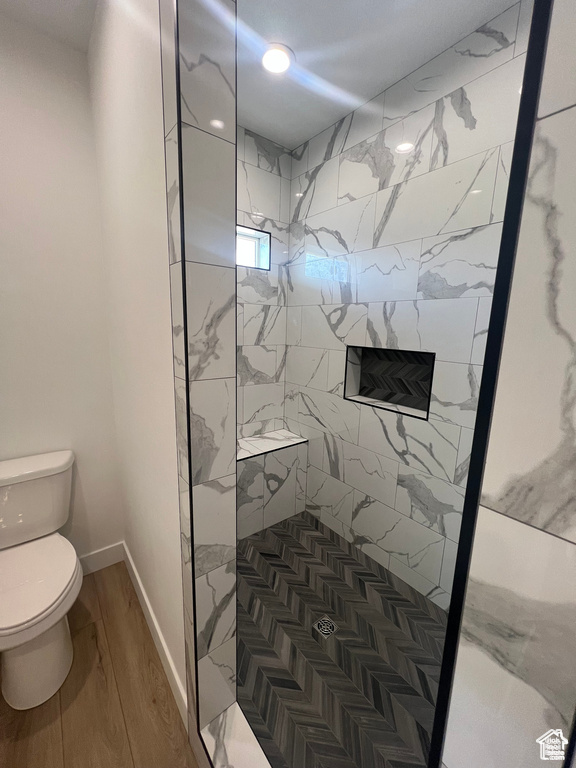 Bathroom featuring walk in shower, toilet, and hardwood / wood-style floors