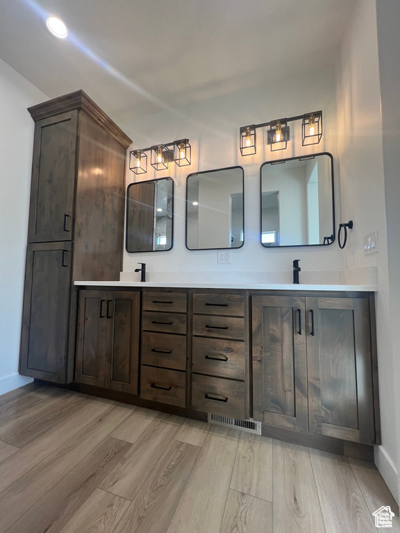 Bathroom with dual vanity and hardwood / wood-style floors