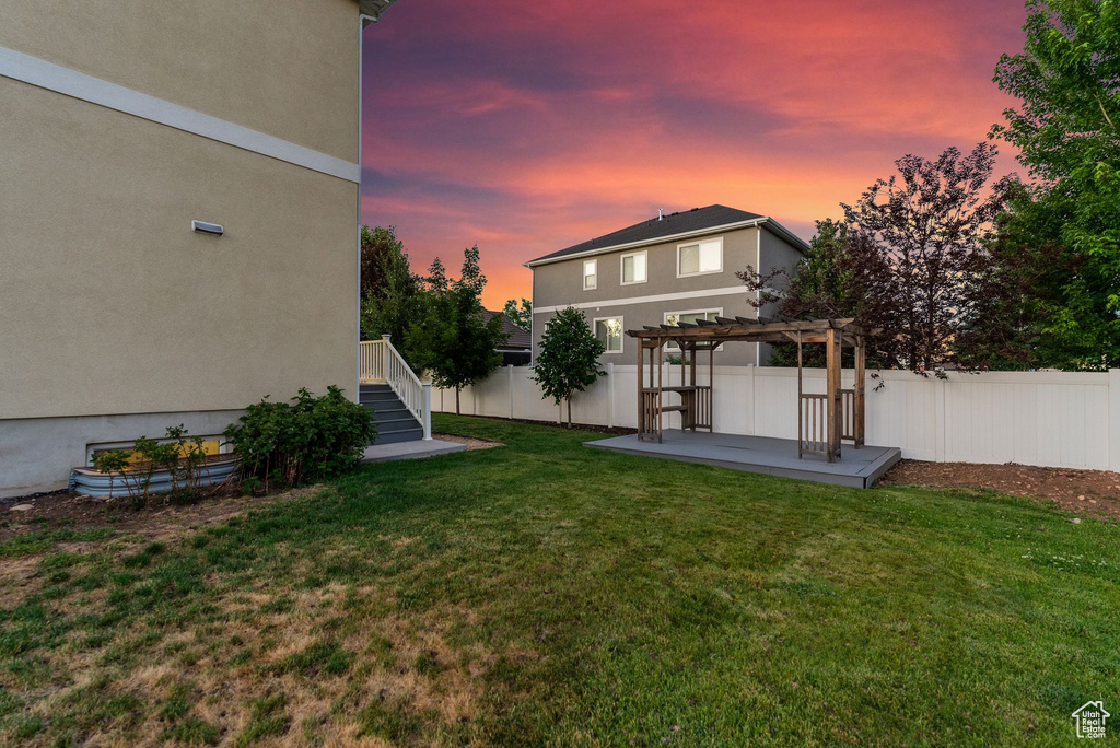 Yard at dusk with a pergola and a patio area