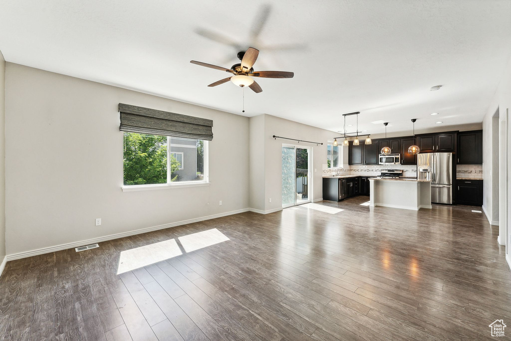 Unfurnished living room featuring hardwood / wood-style floors and ceiling fan