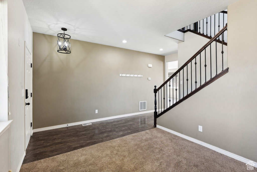 Foyer entrance featuring dark hardwood / wood-style floors and a notable chandelier