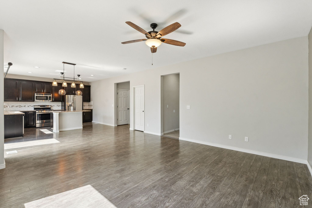 Unfurnished living room featuring sink, ceiling fan, and hardwood / wood-style floors