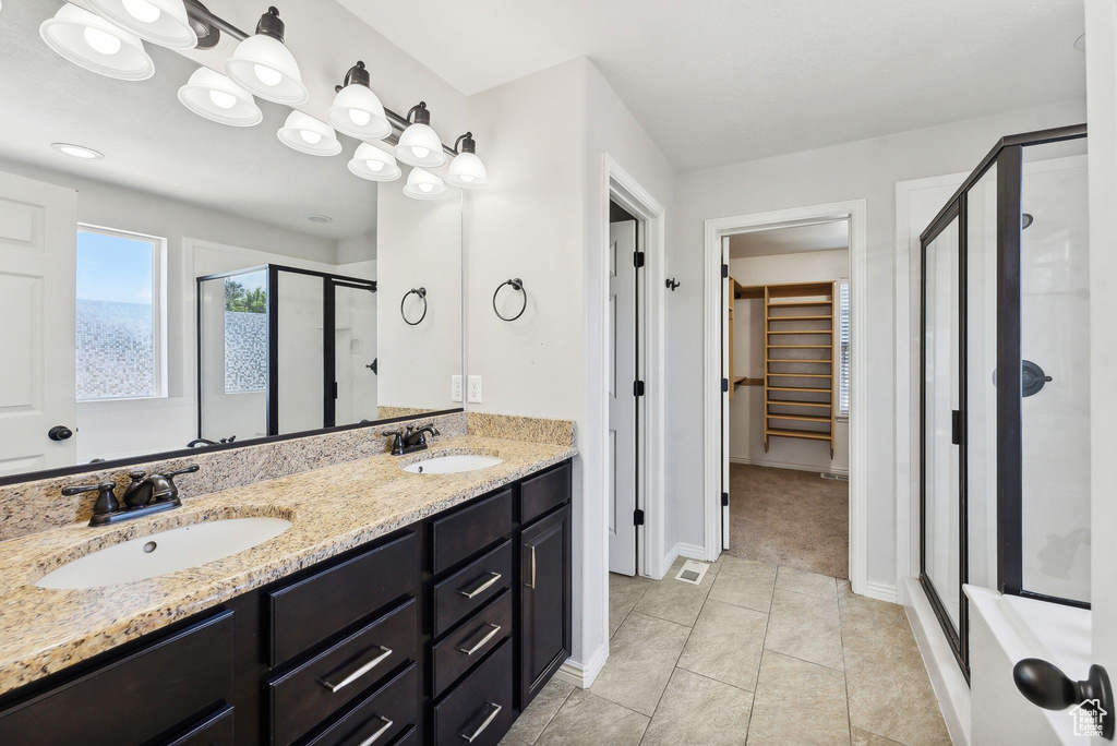 Bathroom featuring tile patterned floors and dual bowl vanity