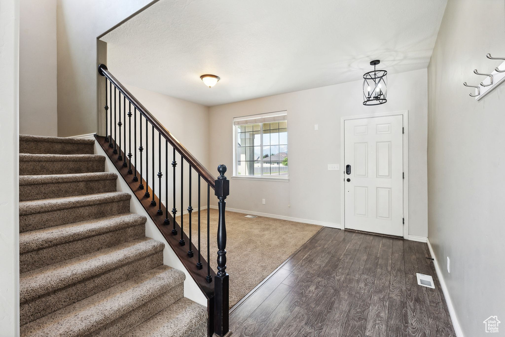 Foyer entrance featuring a chandelier and dark hardwood / wood-style floors