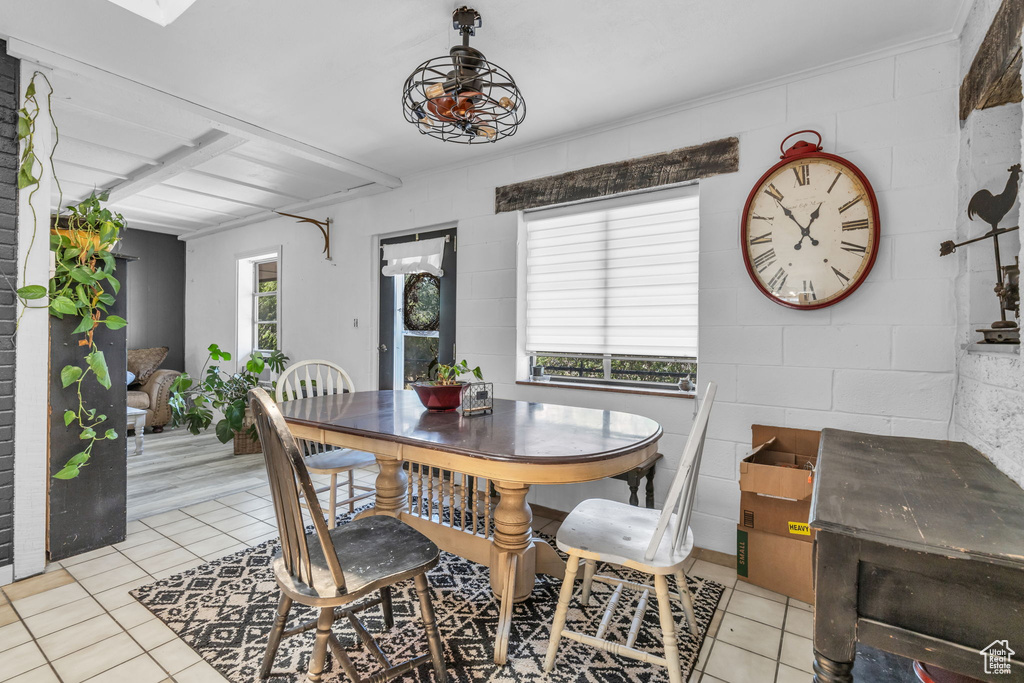 Tiled dining room with a healthy amount of sunlight and ceiling fan