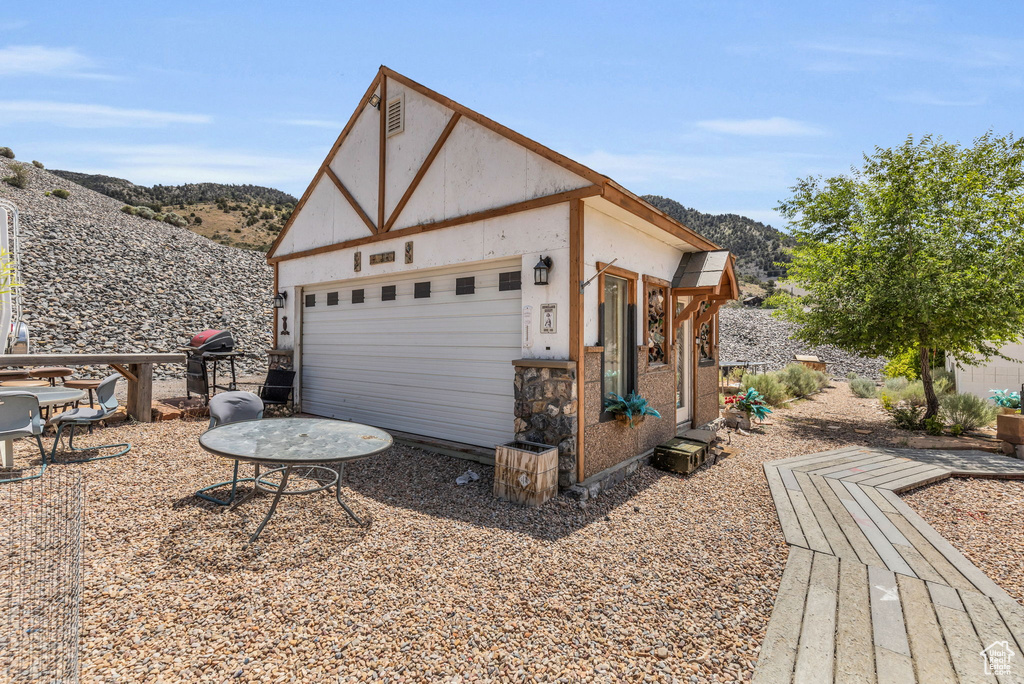 View of property exterior featuring a mountain view, an outbuilding, and a garage