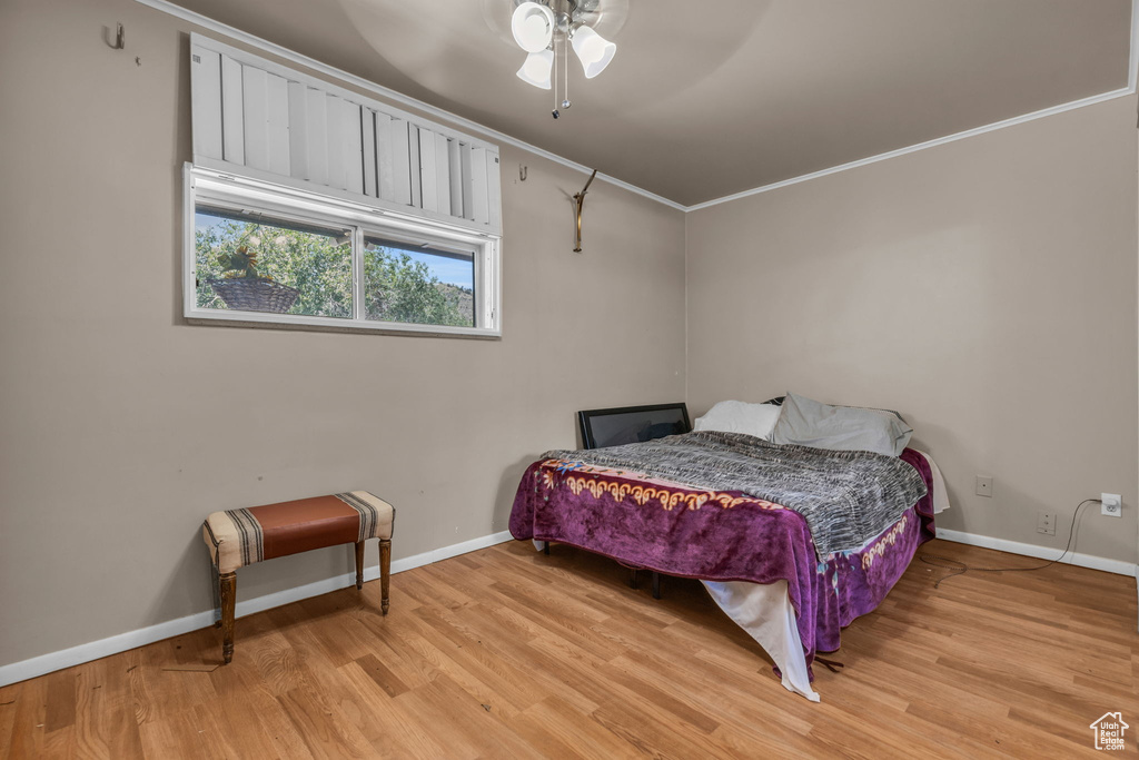 Bedroom featuring ornamental molding, ceiling fan, and light wood-type flooring