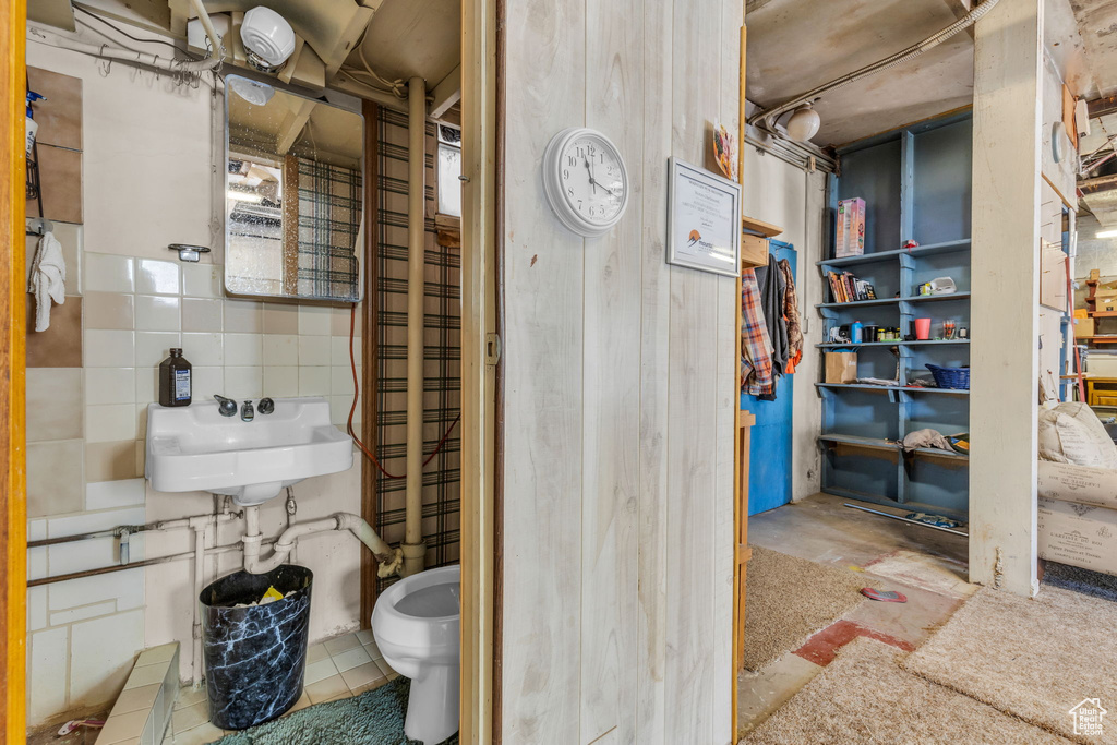 Bathroom with sink, tile walls, and radiator