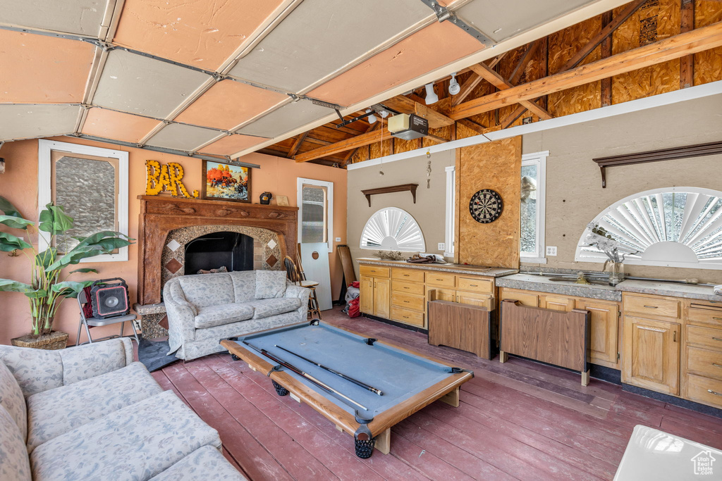 Living room featuring pool table, vaulted ceiling with beams, and hardwood / wood-style floors