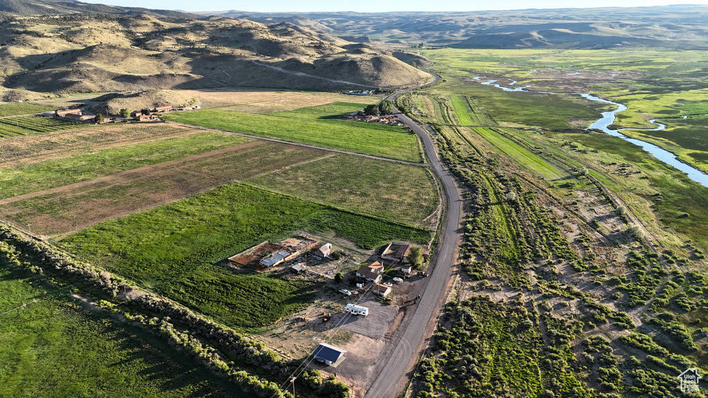Birds eye view of property with a water and mountain view and a rural view