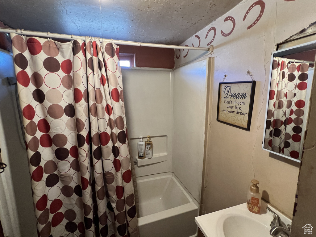Full bath featuring shower / bath combo and a sink