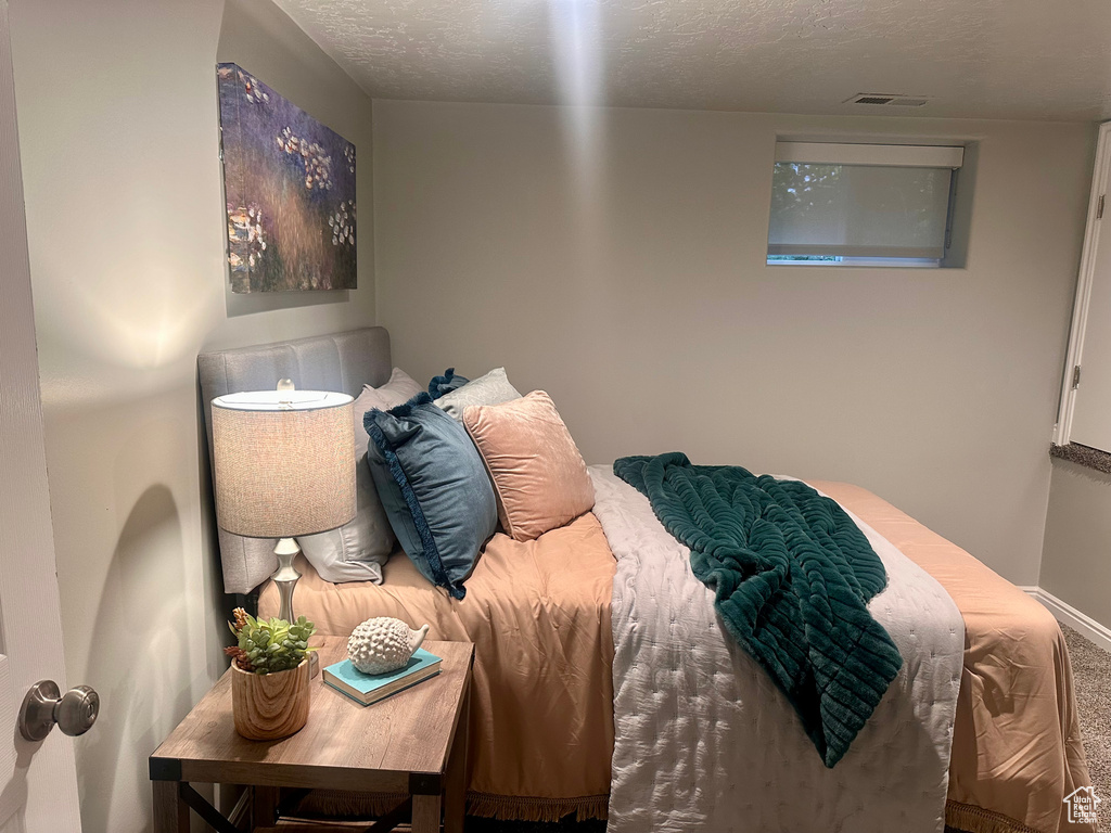 Bedroom with carpet and a textured ceiling