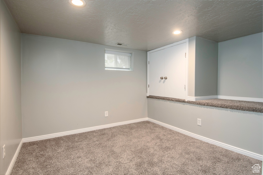 Spare room with carpet and a textured ceiling