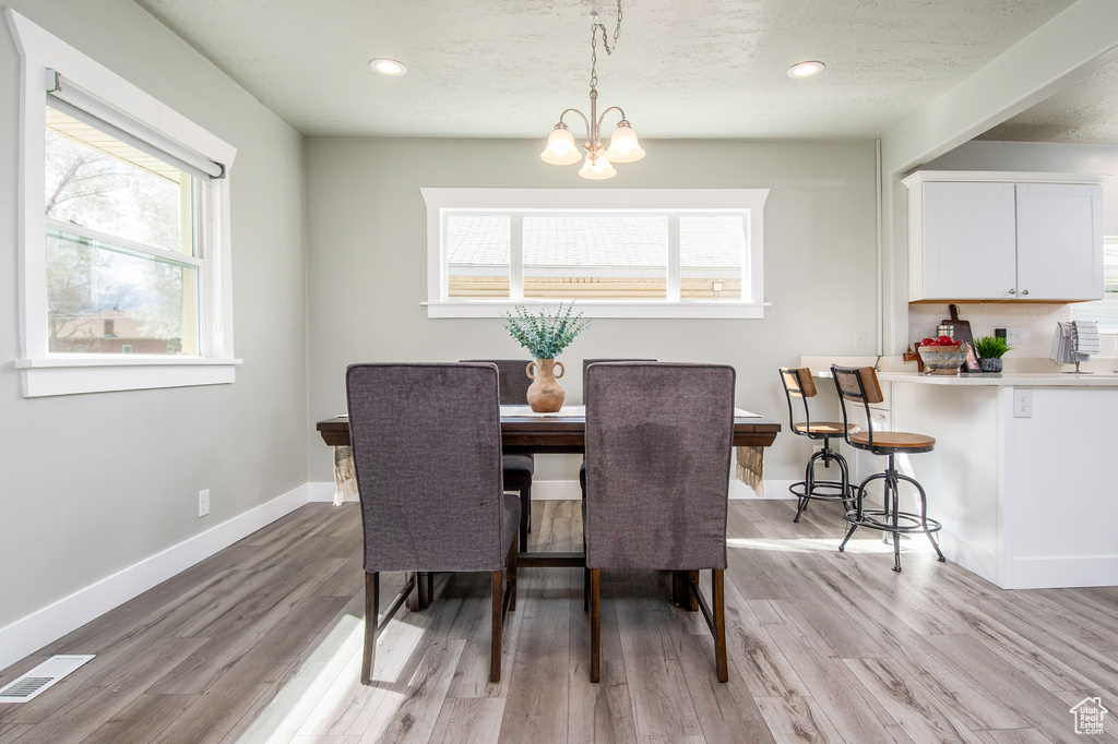 Dining room featuring a chandelier, light hardwood / wood-style floors, and a wealth of natural light