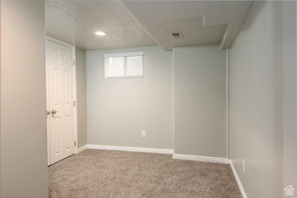 Interior space featuring a textured ceiling and carpet flooring