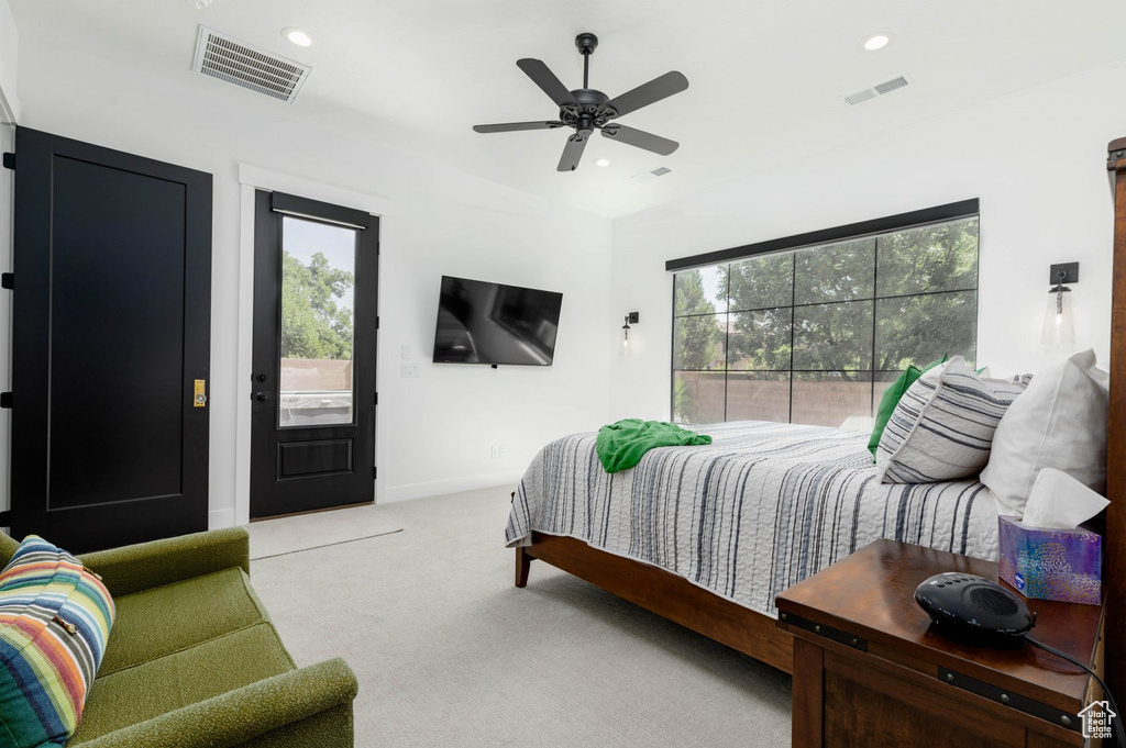 Bedroom featuring light carpet, ceiling fan, and access to exterior