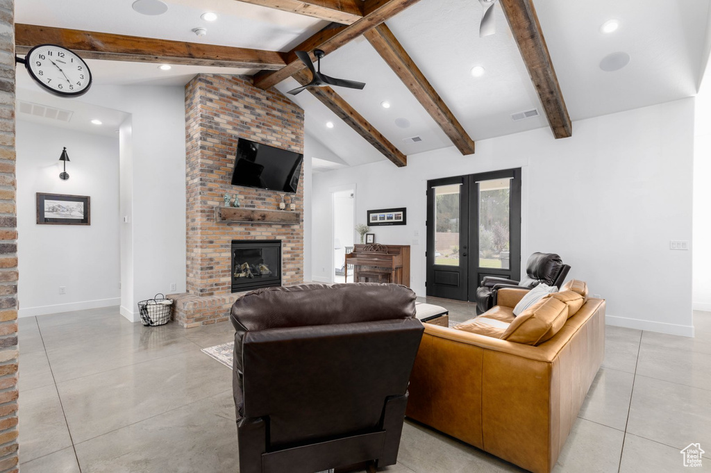 Living room with light tile patterned flooring, a fireplace, french doors, and vaulted ceiling with beams