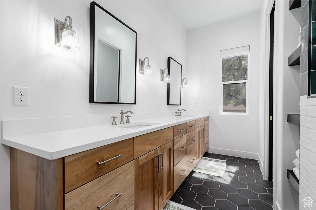 Bathroom featuring tile patterned floors and double sink vanity