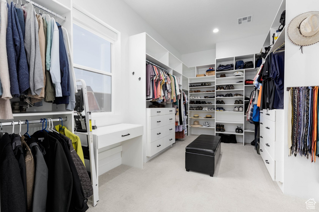 Spacious closet featuring light colored carpet